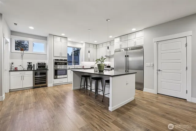 a kitchen with stainless steel appliances a refrigerator and a stove top oven