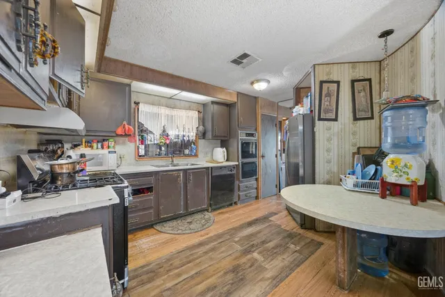 a kitchen with a table chairs refrigerator and a sink