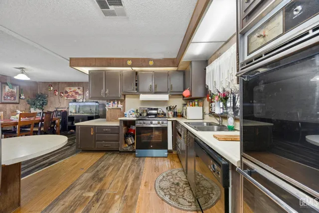 a kitchen with stainless steel appliances kitchen island granite countertop a sink stove and cabinets