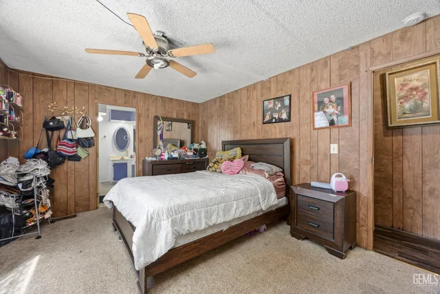 a bedroom with a bed dresser and a large window
