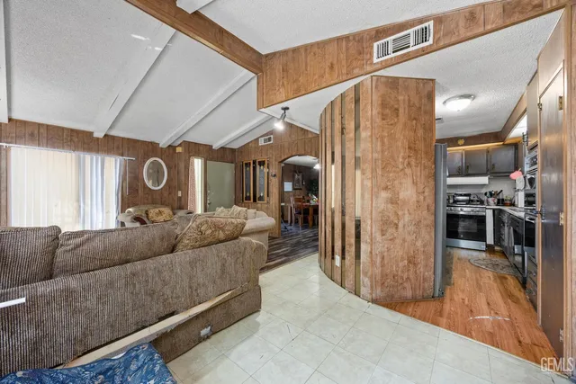 a living room with furniture and a open kitchen view