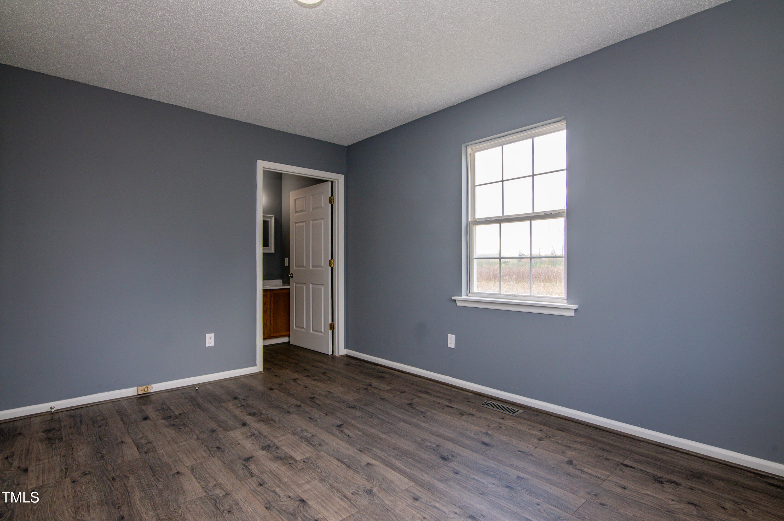 5046 Mrs Mag Road Conway, NC 27820 - Photo 11 of 38 an empty room with wooden floor and windows