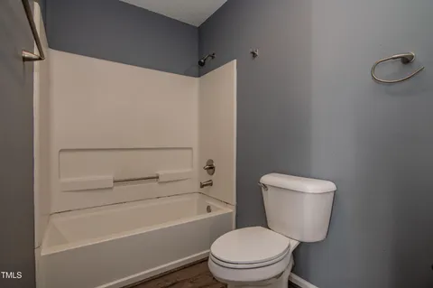 a white toilet sitting next to a bath tub