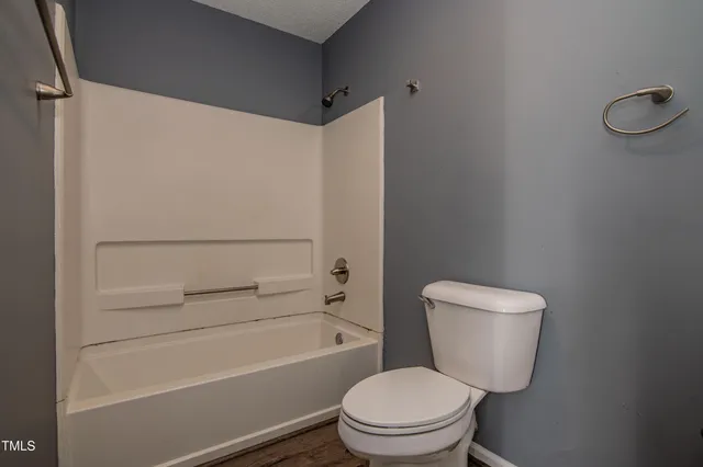 a white toilet sitting next to a bath tub