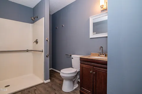a bathroom with a granite countertop toilet a sink and a mirror