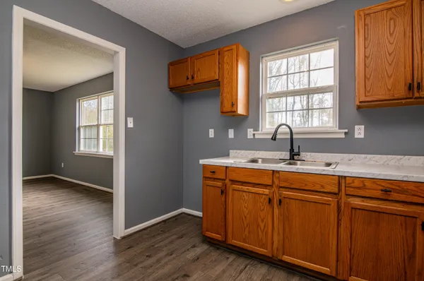 a kitchen with wooden cabinets a sink and a window