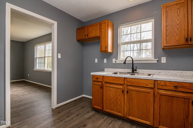 a kitchen with wooden cabinets a sink and a window