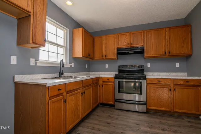 a kitchen with a sink stove top oven and cabinets