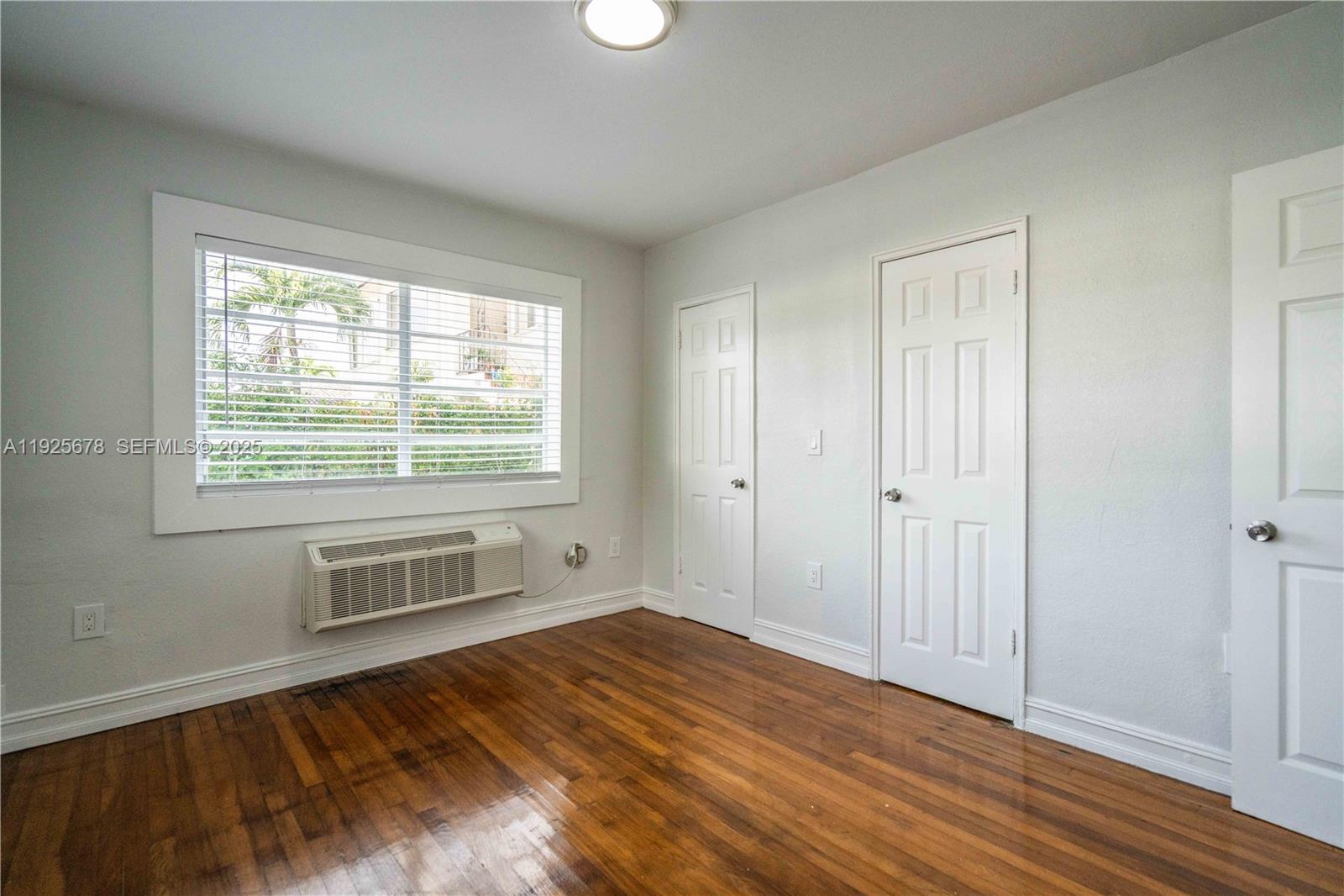 7925 Hawthorne Avenue, Unit 1 Miami Beach, FL 33141 - Photo 18 of 20 a view of an empty room with wooden floor and a window