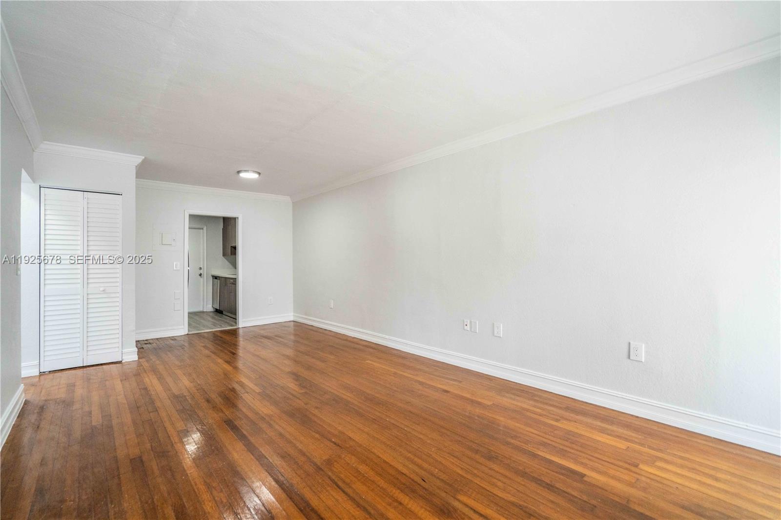7925 Hawthorne Avenue, Unit 1 Miami Beach, FL 33141 - Photo 4 of 20 a view of empty room with wooden floor and windows