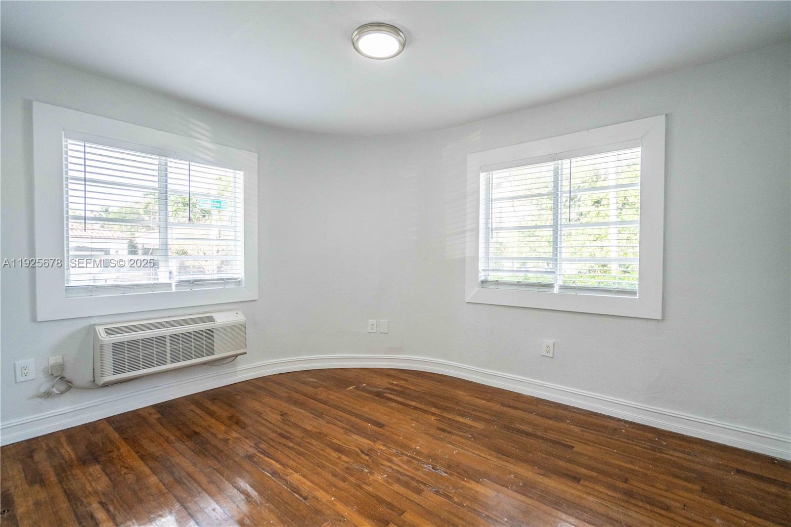 7925 Hawthorne Avenue, Unit 1 Miami Beach, FL 33141 - Photo 10 of 20 a view of an empty room with wooden floor and a window