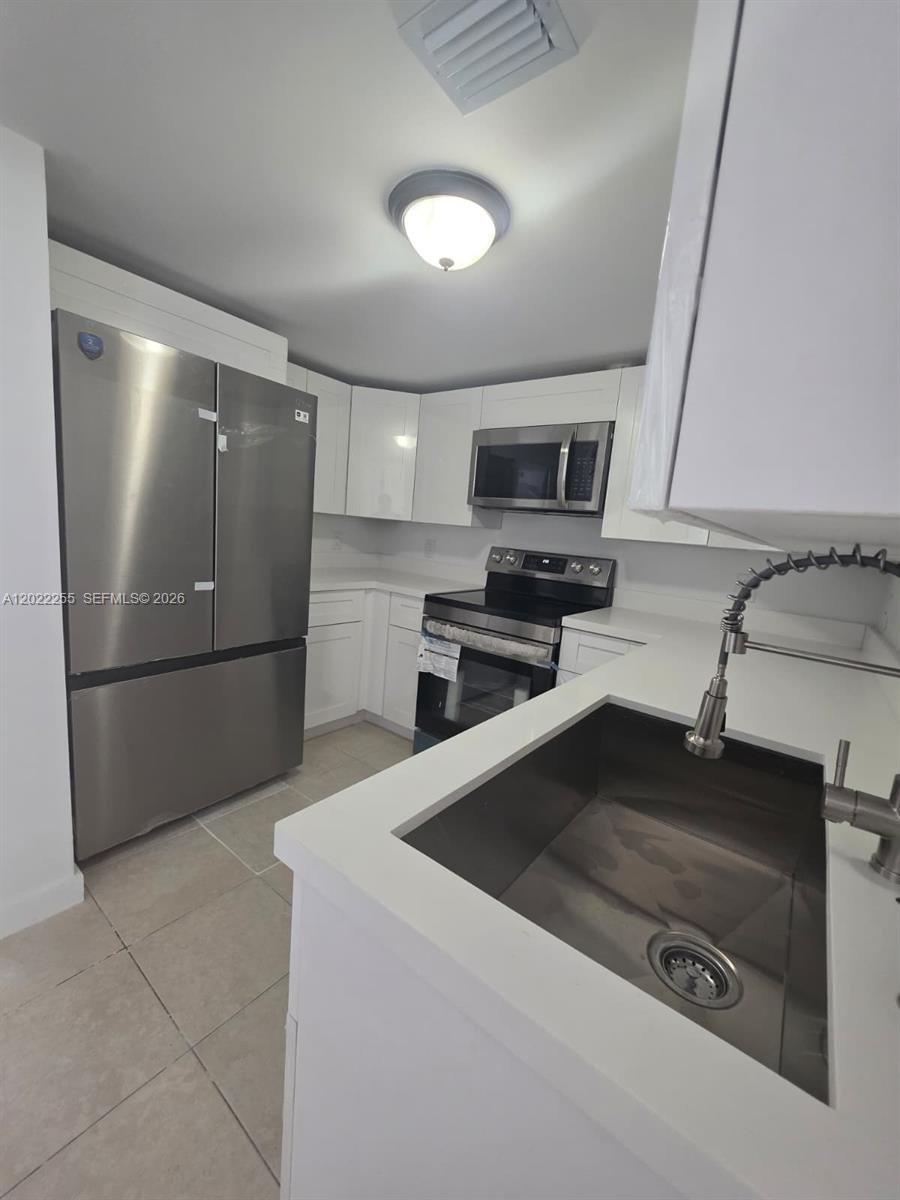 829 Southwest 3rd Street, Unit 831 Miami, FL 33130 - Photo 18 of 21 a kitchen with a refrigerator sink and microwave
