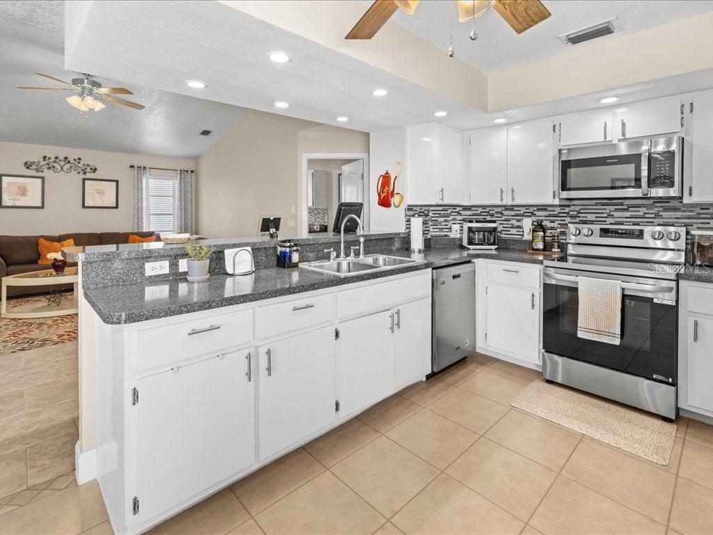 25263 Padre Lane Punta Gorda, FL 33983 - Photo 16 of 60 a kitchen with stainless steel appliances granite countertop a sink and cabinets