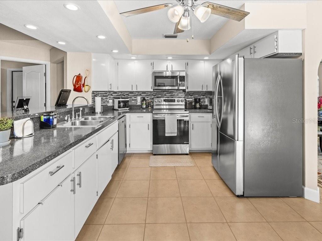 25263 Padre Lane Punta Gorda, FL 33983 - Photo 17 of 60 a large kitchen with stainless steel appliances kitchen island granite countertop a refrigerator and a sink