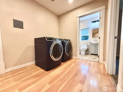 a room with a washing machine and a view of bedroom