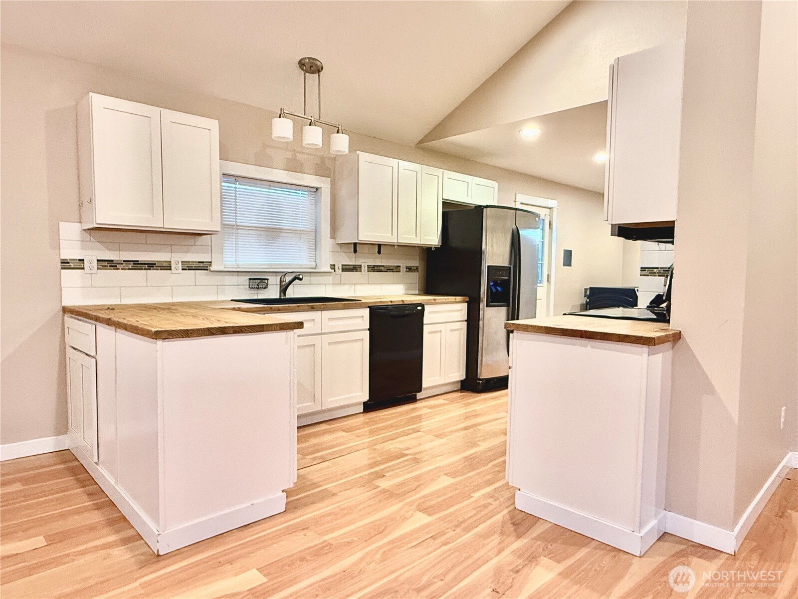 1010 Talcott Street Sedro-Woolley, WA 98284 - Photo 8 of 27 a kitchen with kitchen island a sink a stove a refrigerator and white cabinets