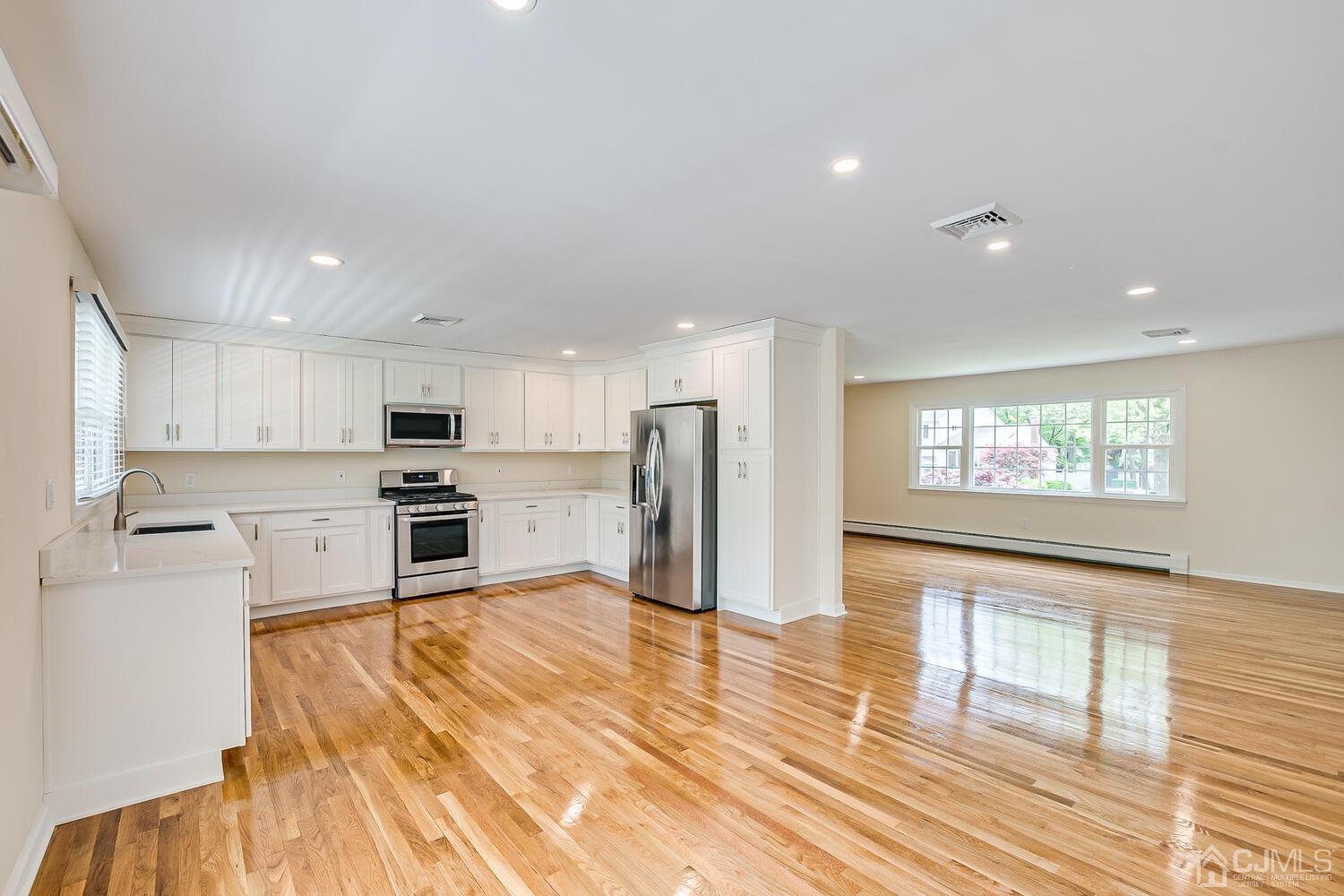8 Eagle Road Edison, NJ 08820 - Photo 6 of 28 a large kitchen with stainless steel appliances wooden floor and a window