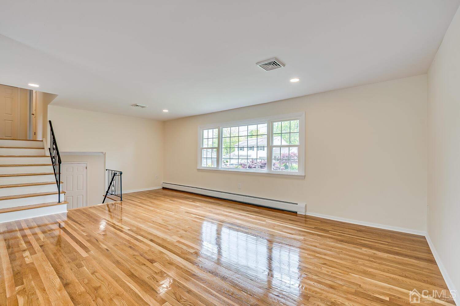 8 Eagle Road Edison, NJ 08820 - Photo 9 of 28 a view of an empty room with wooden floor and a window