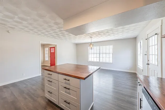 a kitchen with stainless steel appliances granite countertop a refrigerator a sink a stove a dining table and chairs