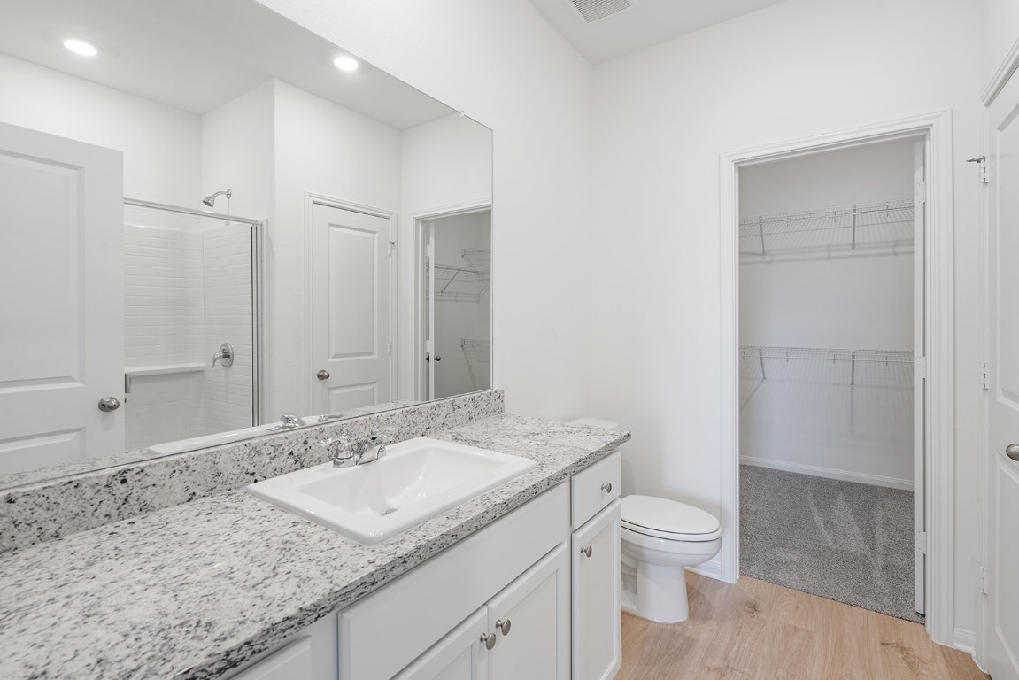 108 Paria Court Jarrell, TX 76537 - Photo 4 of 6 a bathroom with a granite countertop sink a toilet and shower