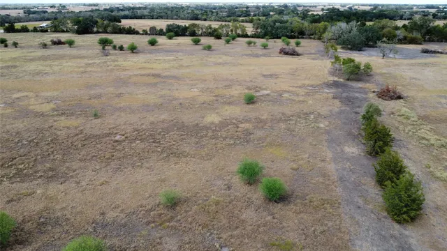 a view of a dry yard with wooden fence