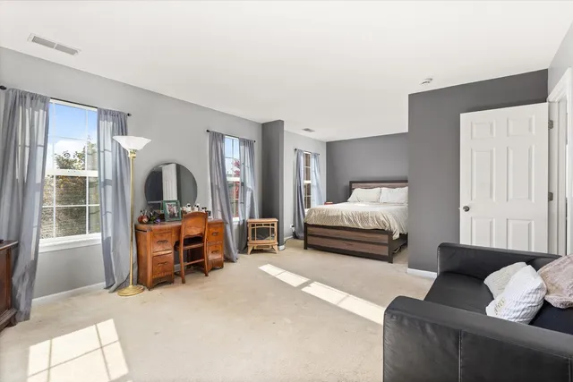 a large bed sitting in a bedroom next to a window