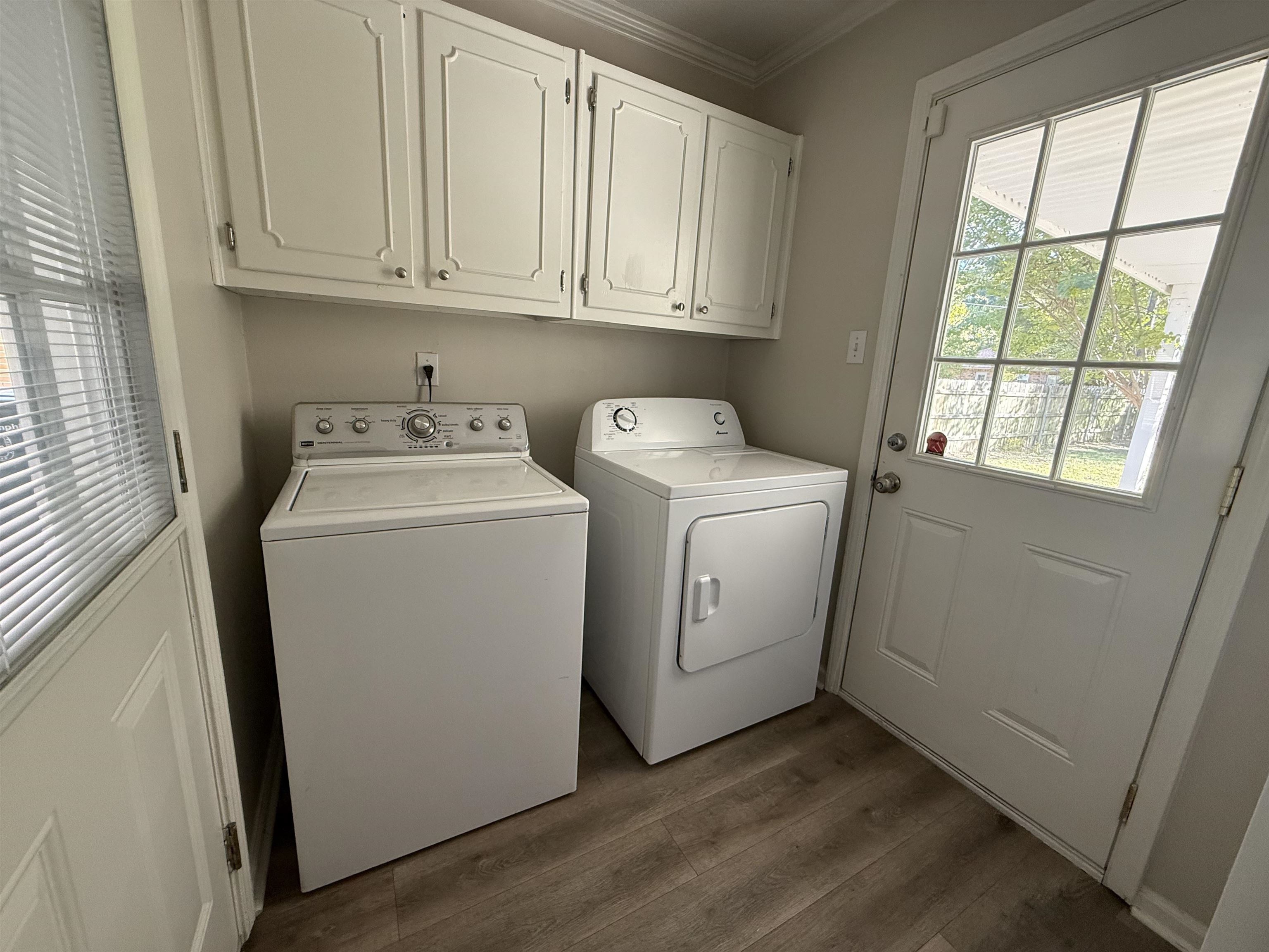 5701 Baird Drive Memphis, TN 38119 - Photo 4 of 12 Washroom featuring dark wood finished floors, crown molding, cabinet space, and separate washer and dryer