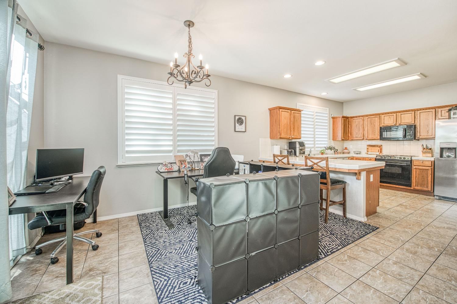 1648 North Avignon Lane Clovis, CA 93619 - Photo 9 of 27 a living room with furniture a dining table and a piano
