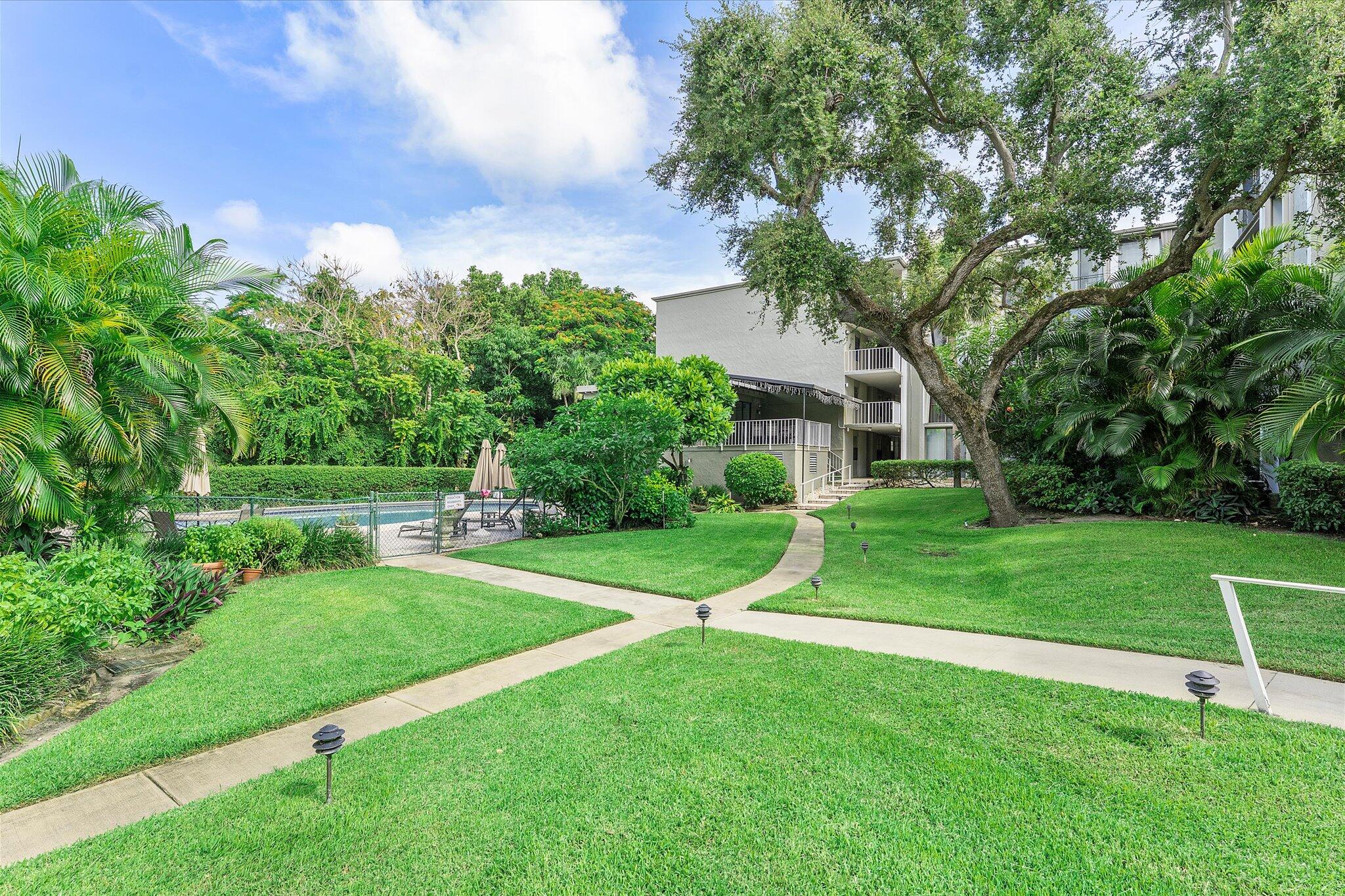 501 Southwest 11th Place, Unit 418 Boca Raton, FL 33432 - Photo 26 of 35 a view of a house with a big yard and a large tree