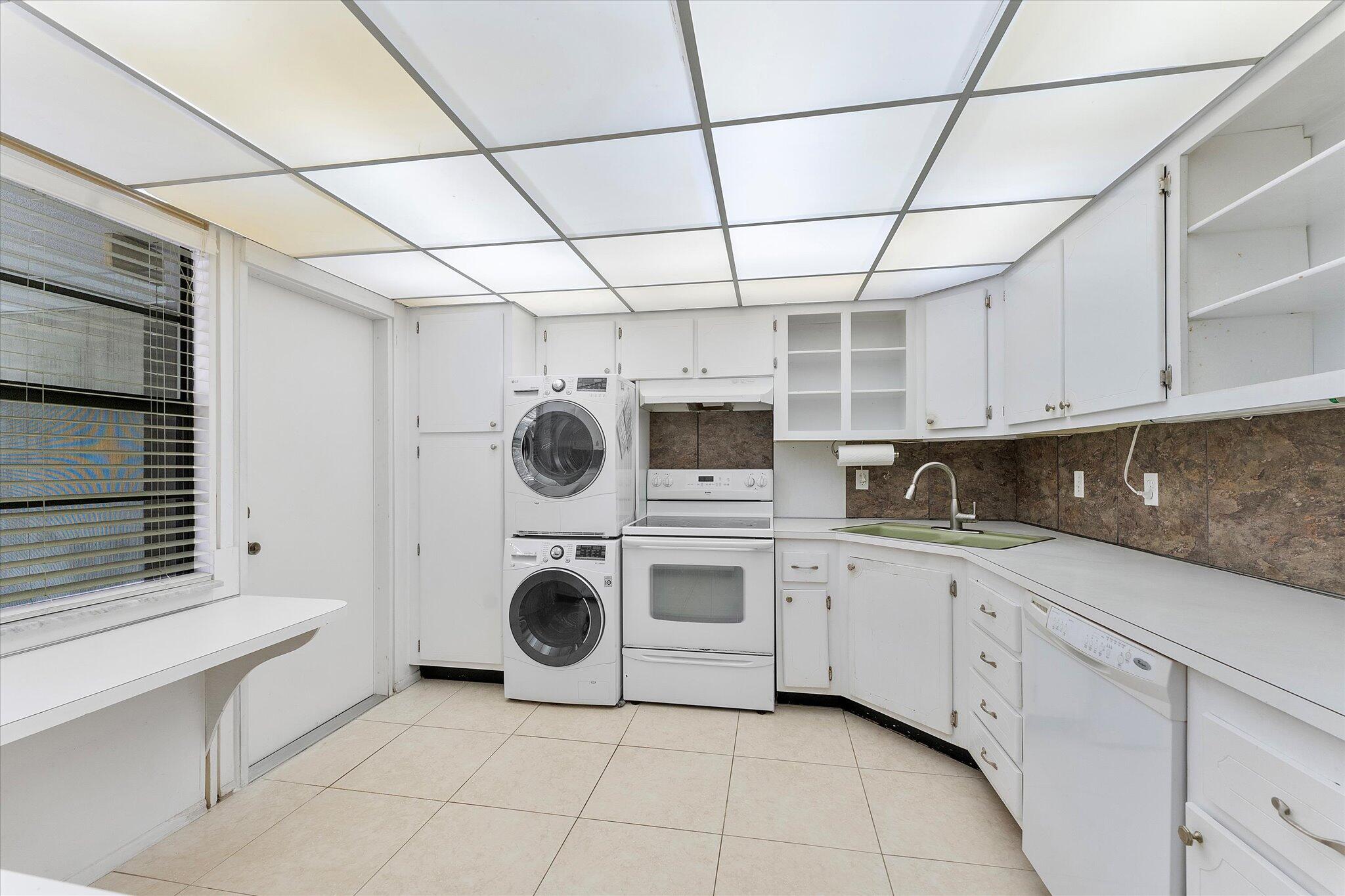 501 Southwest 11th Place, Unit 418 Boca Raton, FL 33432 - Photo 9 of 35 a kitchen with a stove sink and cabinets
