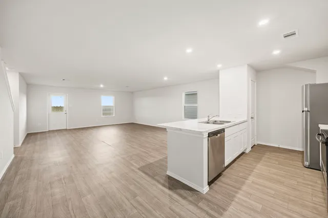 a view of a kitchen with wooden floor and electronic appliances