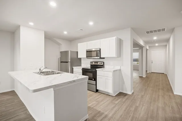 a kitchen with white cabinets and stainless steel appliances
