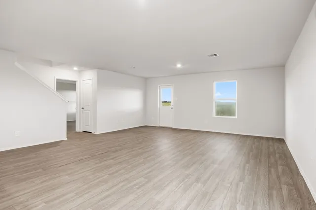 an empty room with wooden floor and window