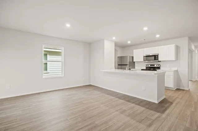 a view of kitchen with wooden floor and electronic appliances