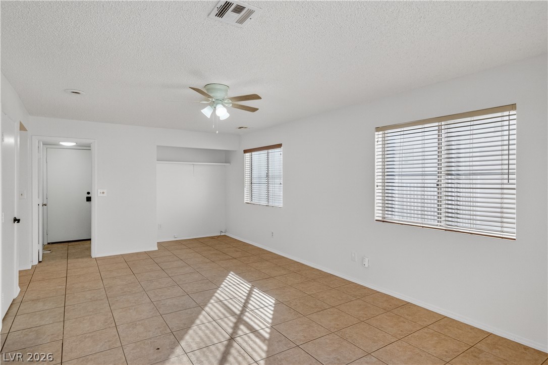 3156 Terrace View Drive Laughlin, NV 89029 - Photo 23 of 94 A well-lit bedroom with tile flooring and a conveniently placed closet for storage.
