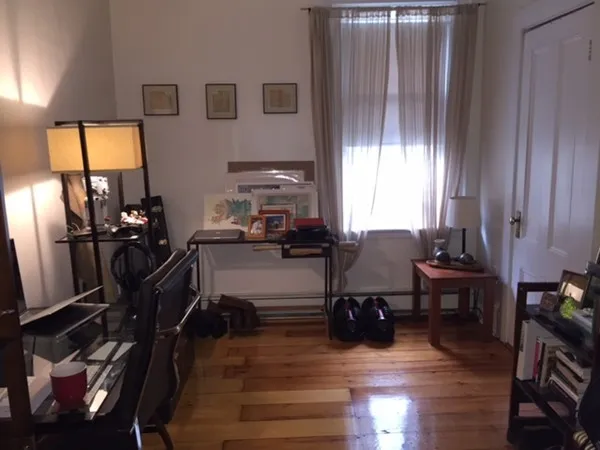 a view of a workspace with furniture and a window