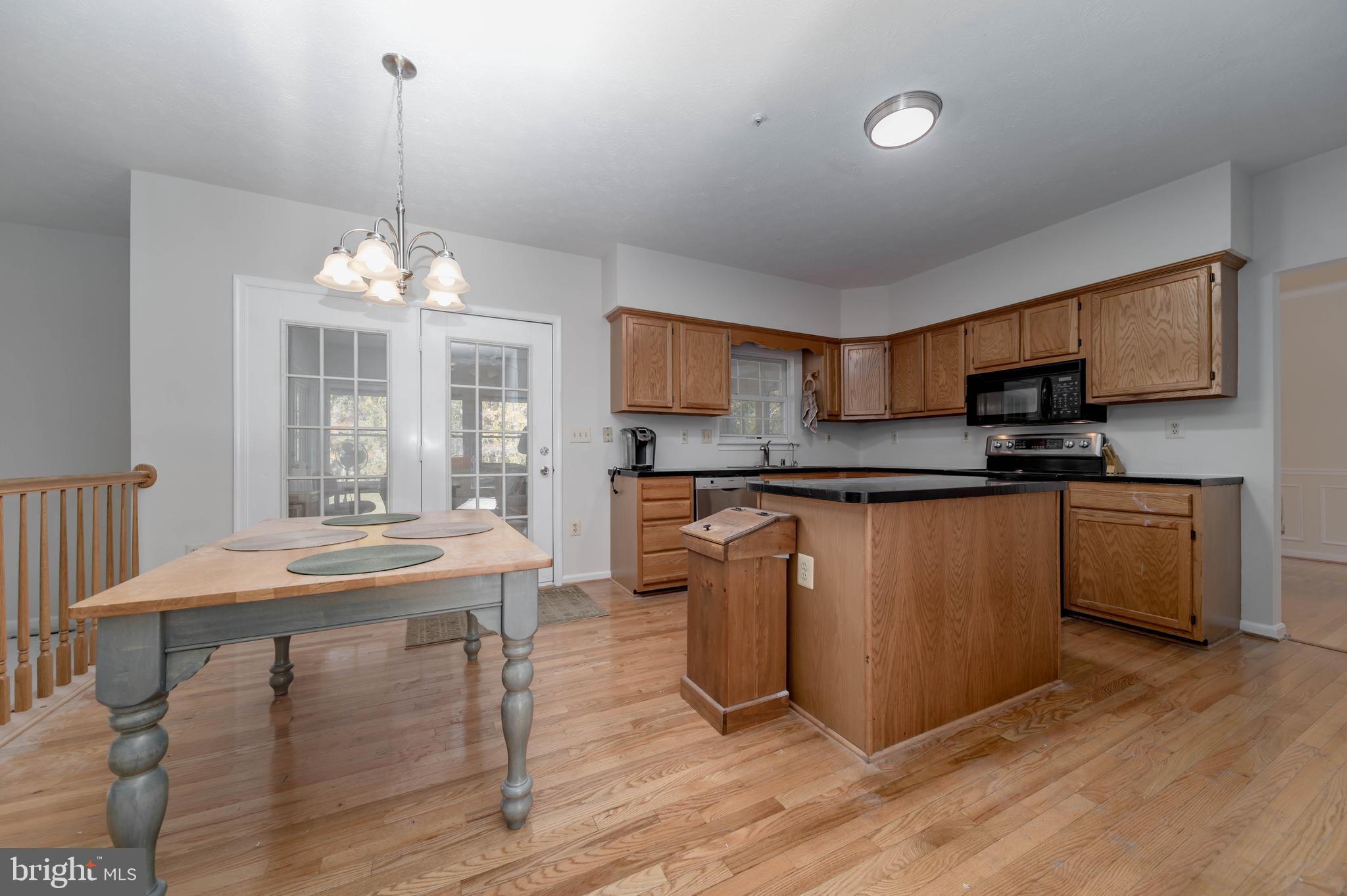 620 Small Reward Road Huntingtown, MD 20639 - Photo 3 of 33 a kitchen with stainless steel appliances granite countertop a stove top oven a sink dishwasher and a refrigerator with wooden floor