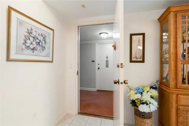 a view of a hallway with wooden floor and a bathroom