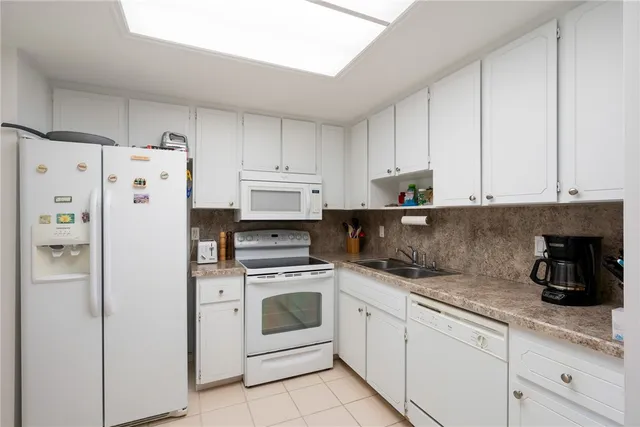 a kitchen with white cabinets and white appliances