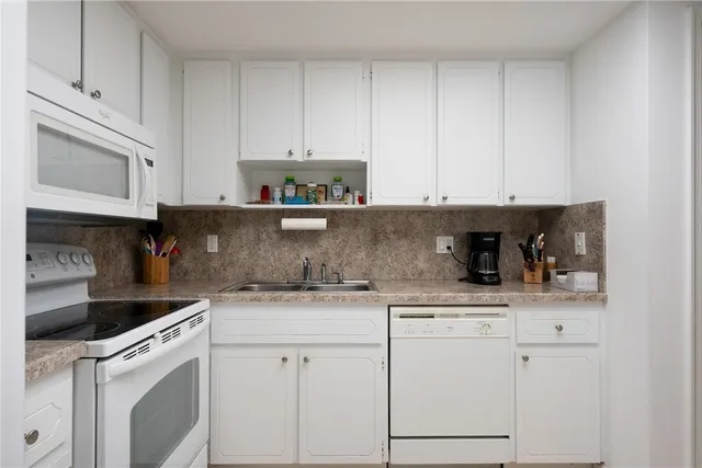a kitchen with stainless steel appliances granite countertop white cabinets sink and dishwasher