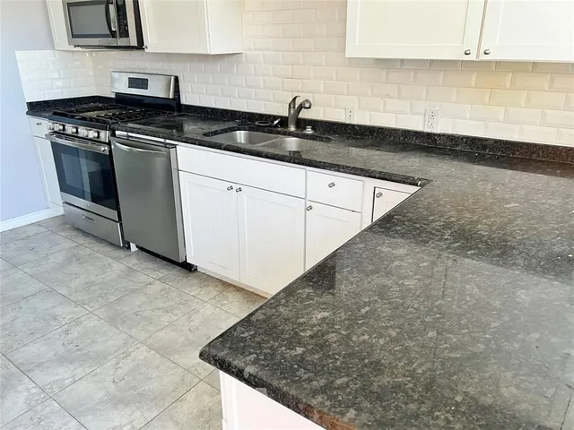 a kitchen with granite countertop a sink and a stove