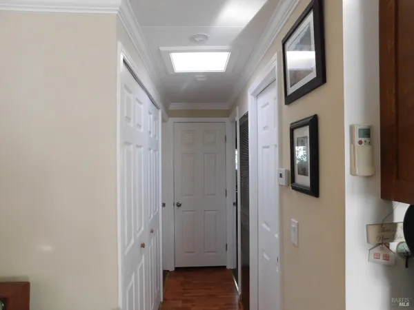 a view of a hallway with wooden floor and closet