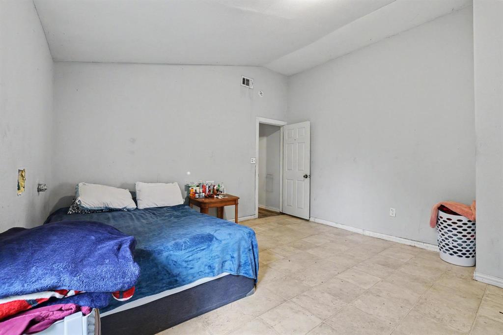 205 South Main Street Bonham, TX 75418 - Photo 8 of 23 a bedroom with a bed and a lamp