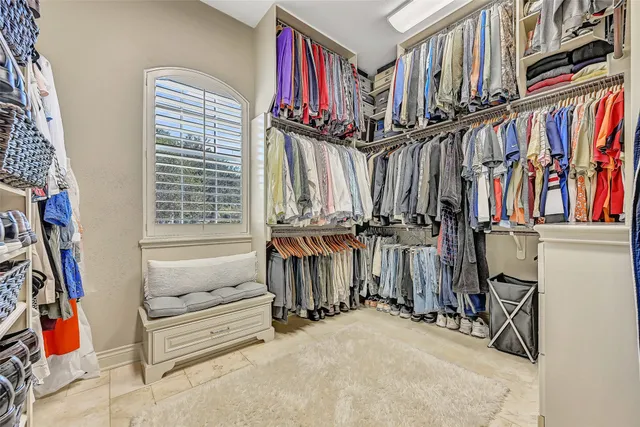 a view of walk in closet with clothes and shoes