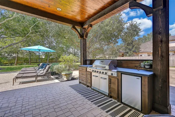 a view of a patio with table and chairs potted plants with wooden floor and fence