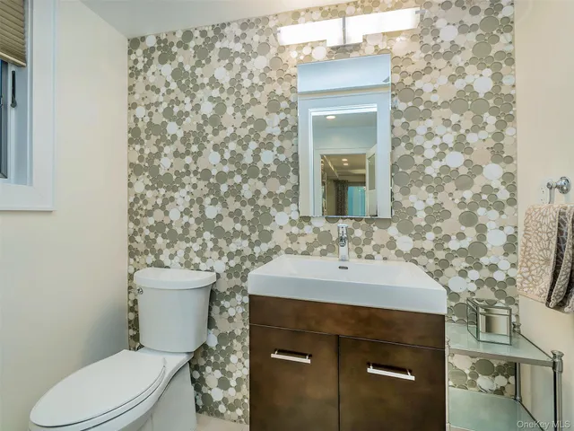 a bathroom with a sink toilet and mirror