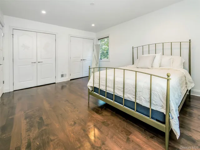 a white bed sitting in a room next to a window