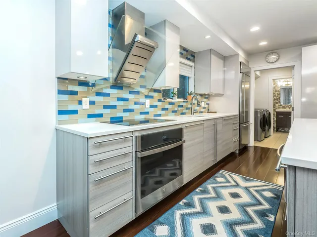 a kitchen with stainless steel appliances a stove and a sink