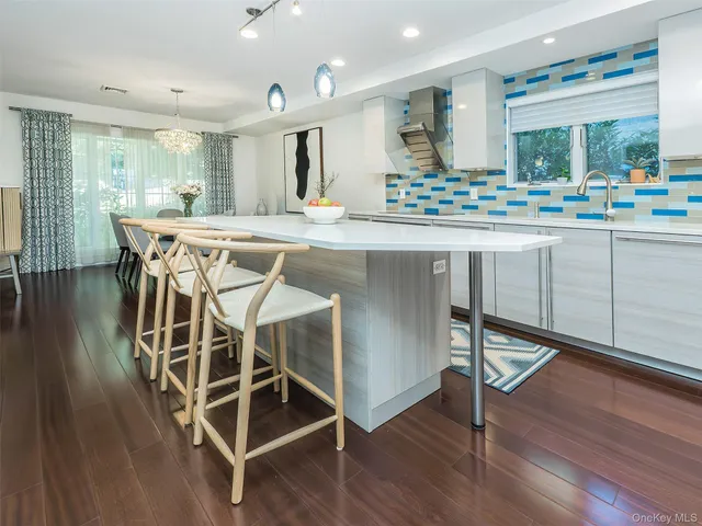 a kitchen with kitchen island granite countertop wooden floors and sink