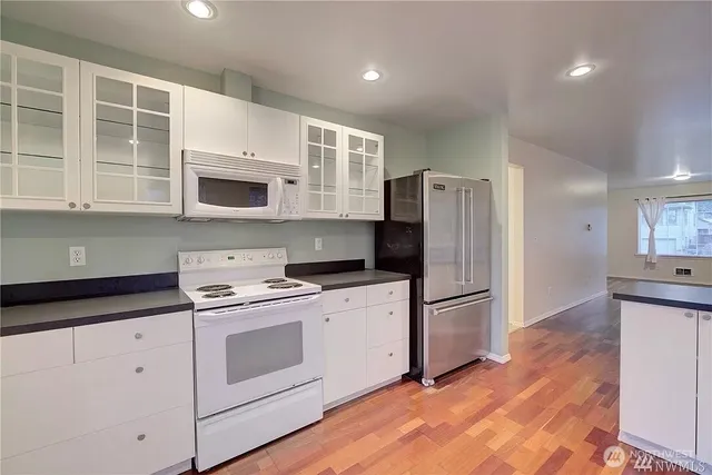 a kitchen with granite countertop white cabinets and stainless steel appliances